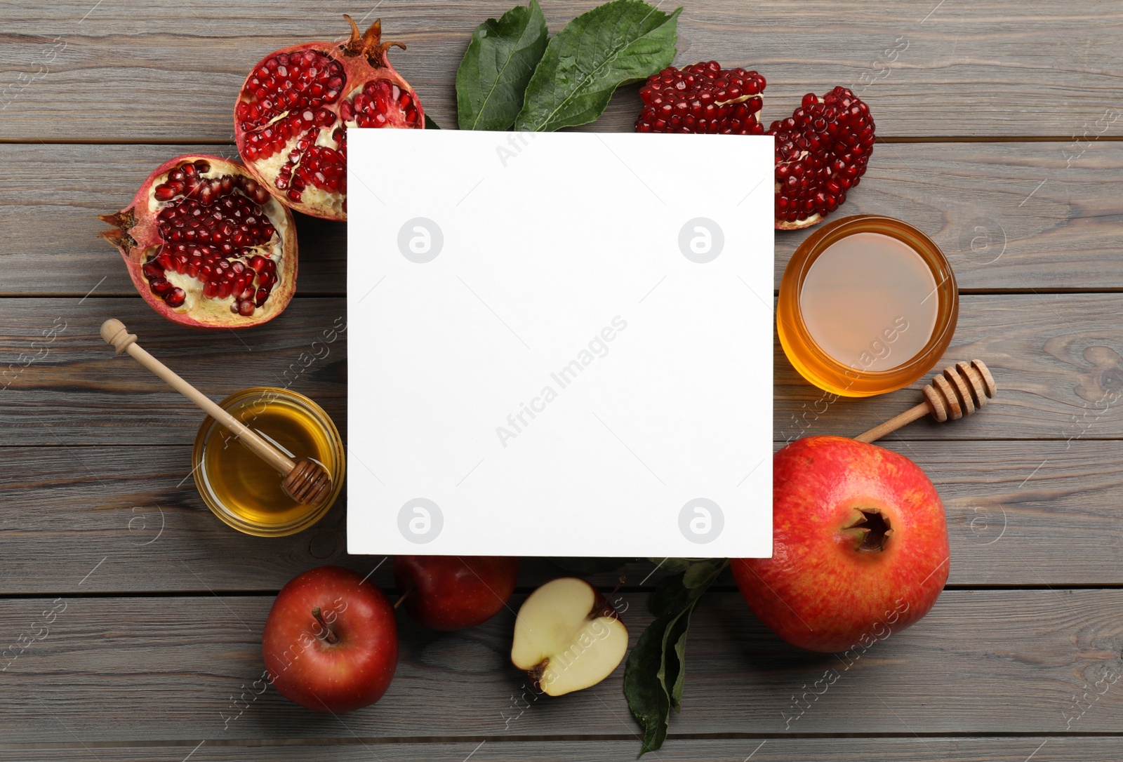Photo of Flat lay composition with Rosh Hashanah holiday attributes and card on grey wooden table. Space for text