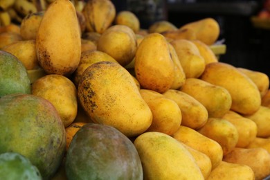 Photo of Pile of delicious ripe yellow mangoes, closeup