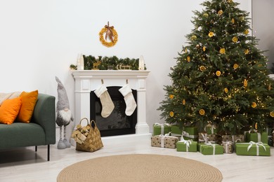 Cozy living room with fireplace and gifts under Christmas tree. Interior design