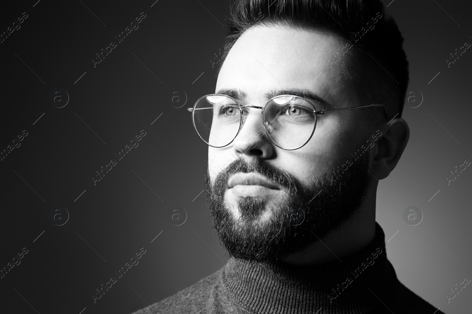 Photo of Portrait of handsome bearded man on dark background. Black and white effect