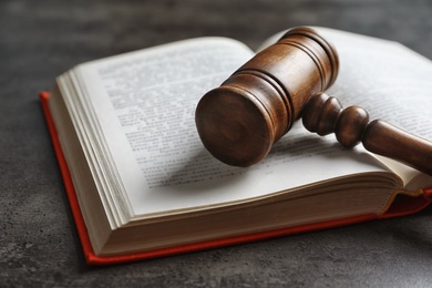 Photo of Wooden gavel and book on dark background. Law concept