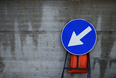 Photo of Road sign KEEP LEFT near concrete wall outdoors, space for text