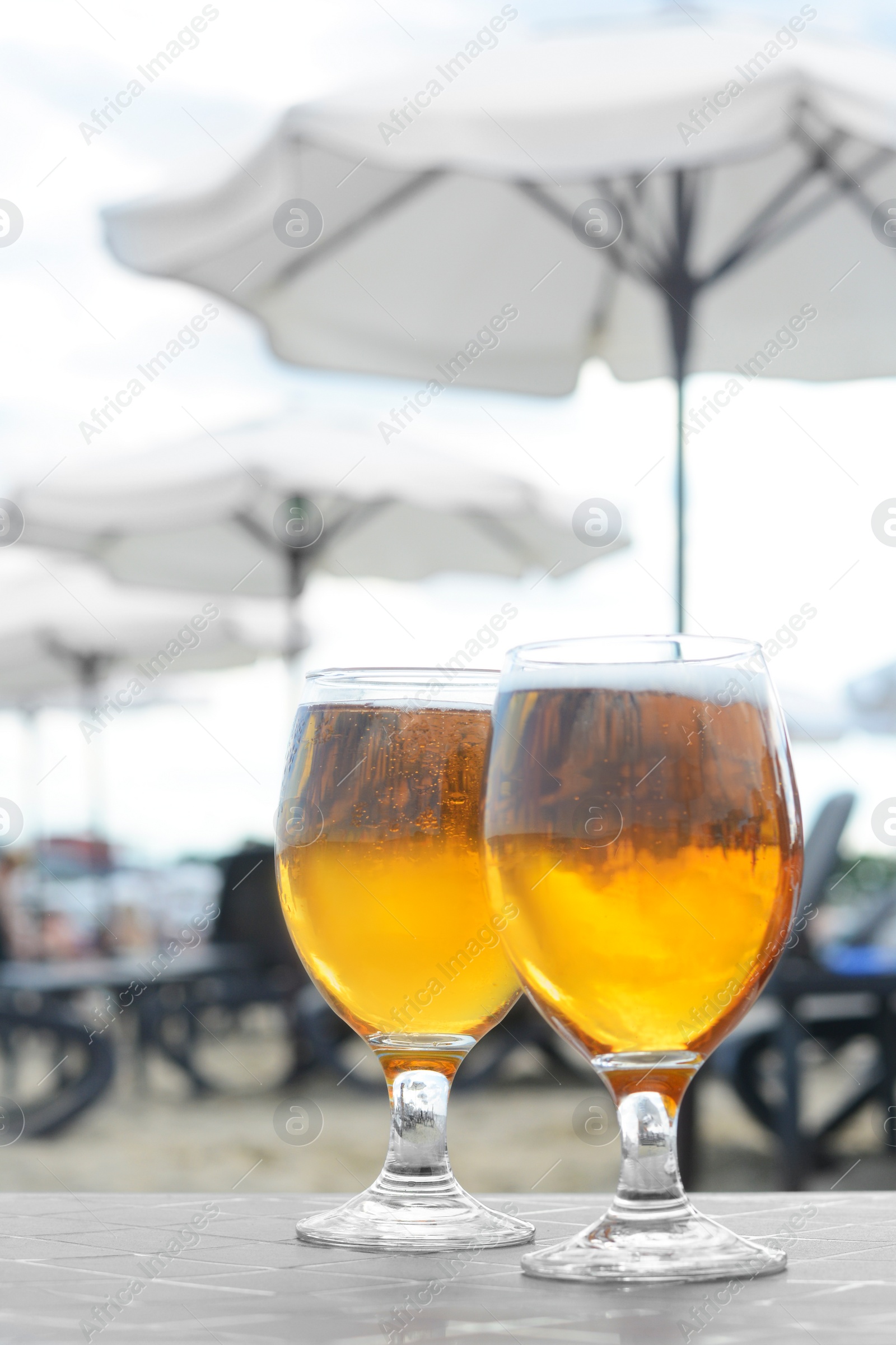 Photo of Cold beer in glass on beach. Space for text