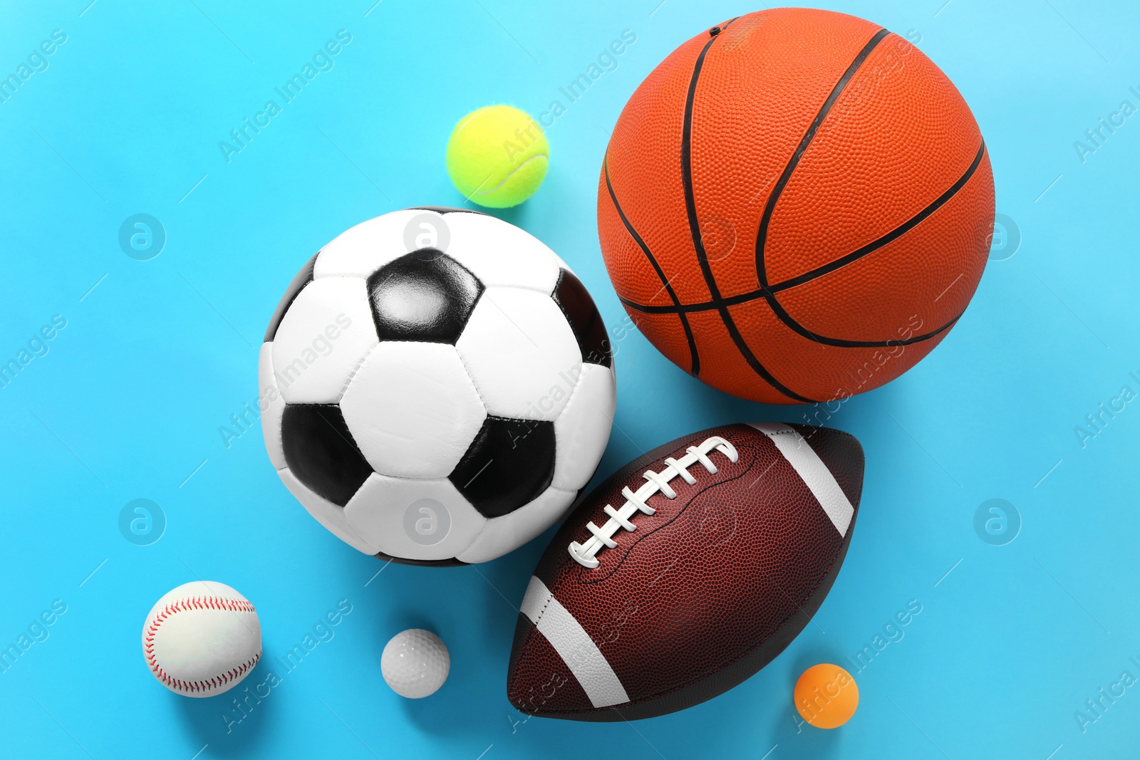 Photo of Many different sports balls on light blue background, flat lay