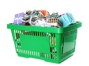 Photo of Green shopping basket with different gifts on white background