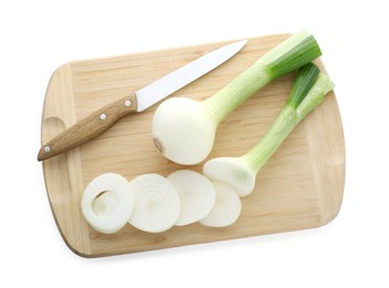 Photo of Wooden board with knife, whole and cut spring onions isolated on white, top view