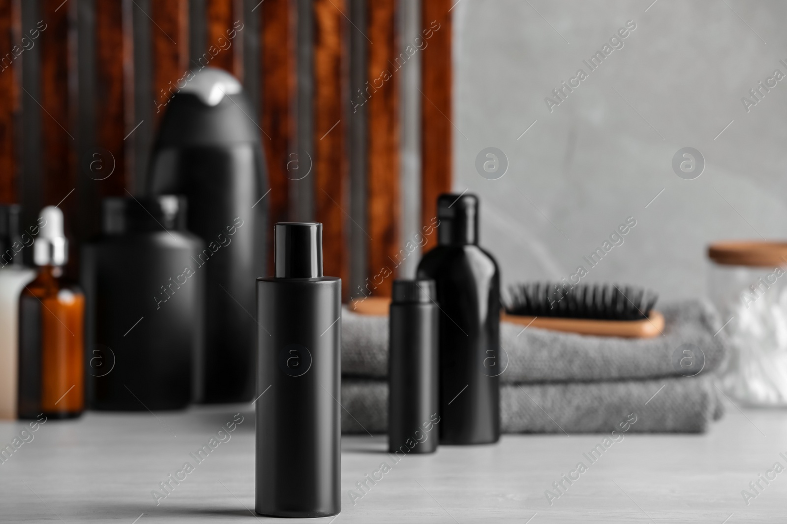 Photo of Bottle of shampoo and toiletries on white table indoors, space for text