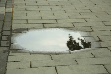 Photo of View of puddle on paving stones outdoors