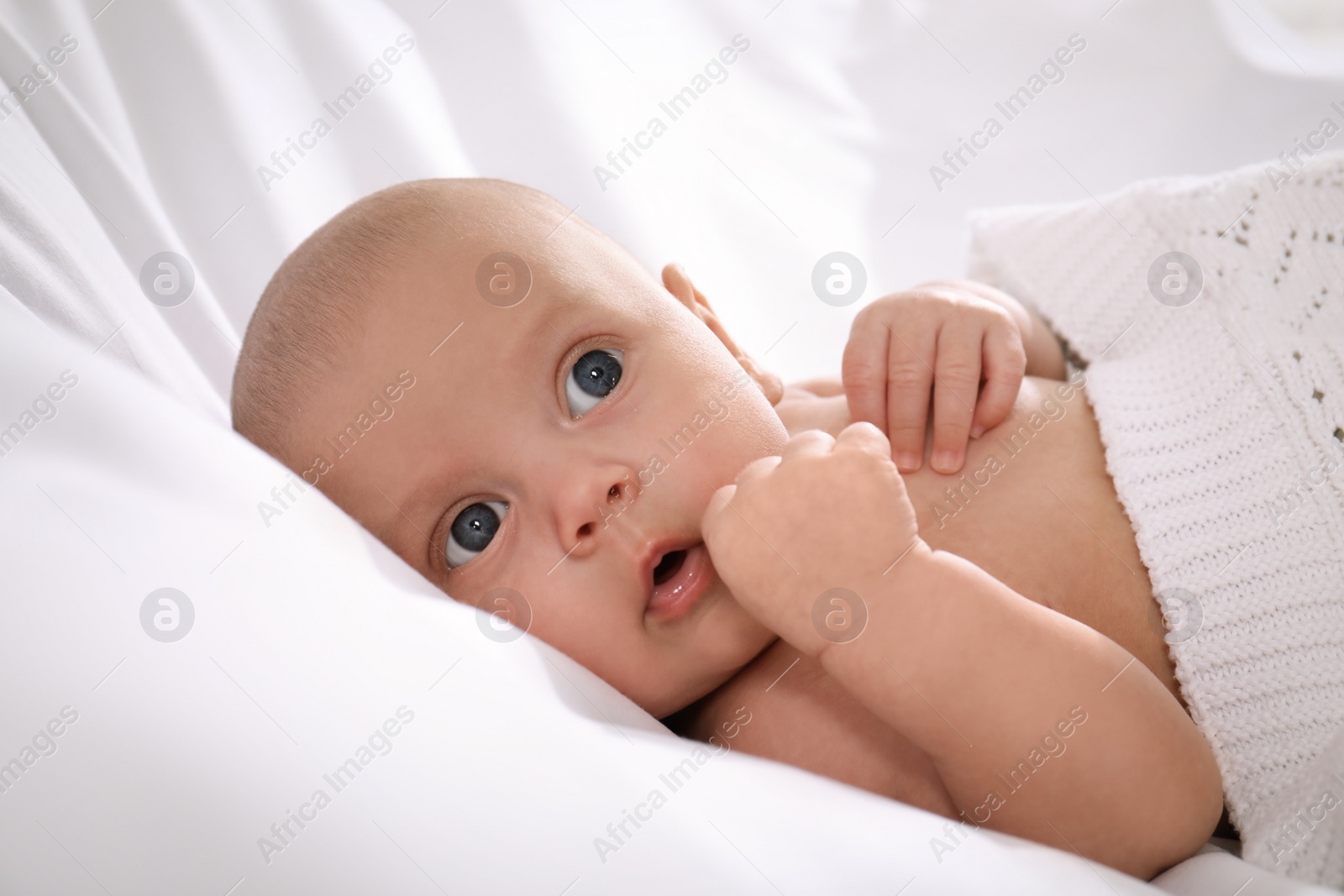 Photo of Cute little baby lying in bed, closeup