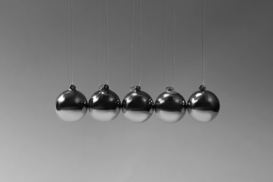 Photo of Newton's cradle on grey background. Physics law of energy conservation