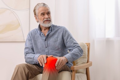 Man suffering from rheumatism in knee at home