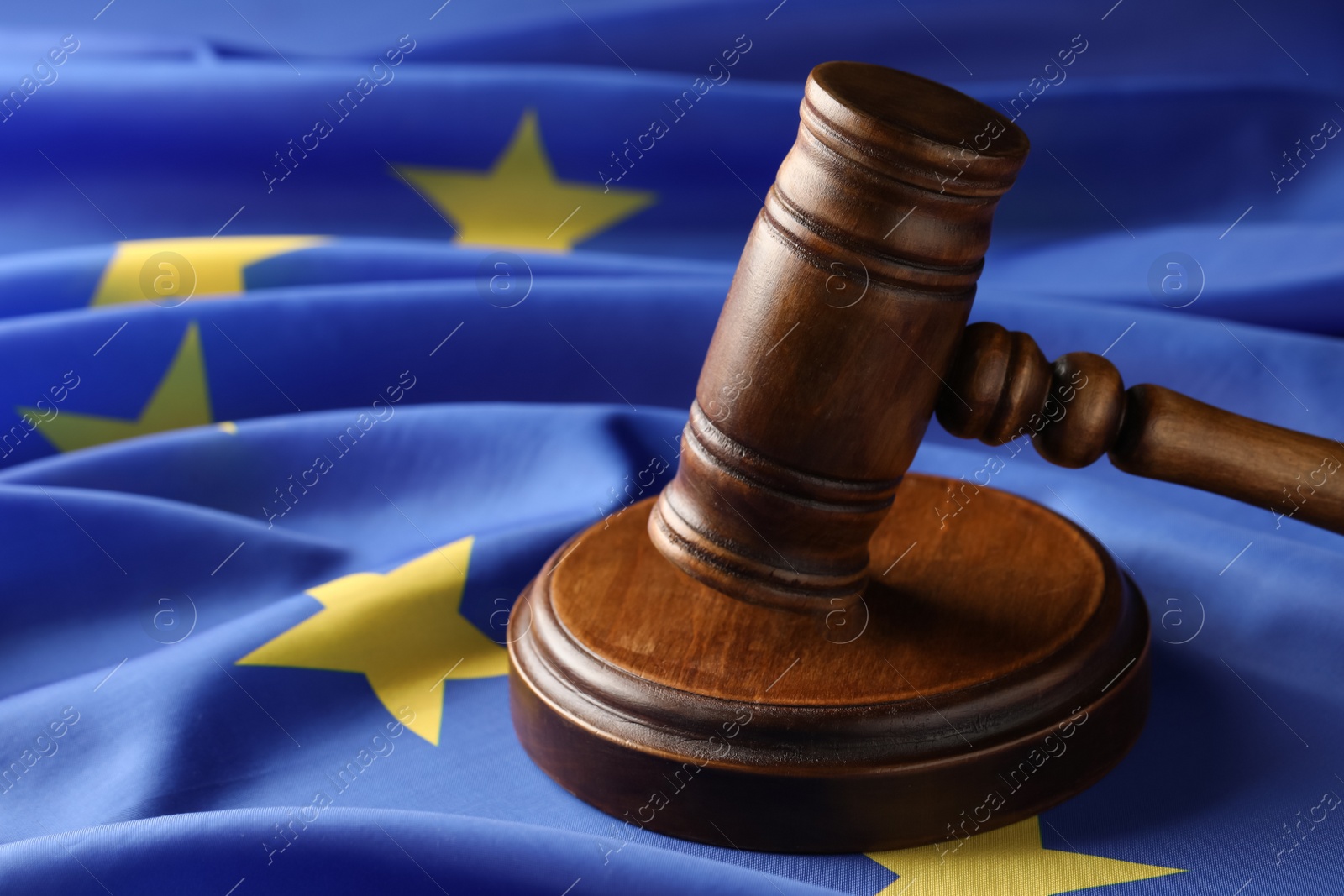 Photo of Wooden judge's gavel on flag of European Union, closeup