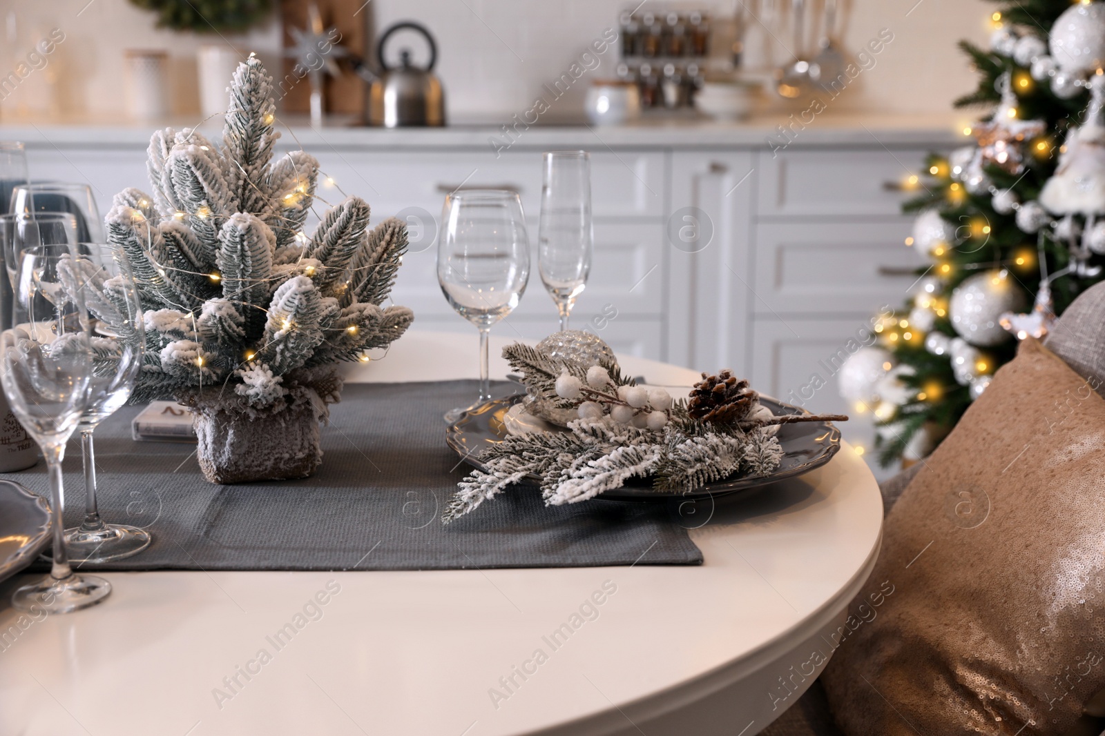 Photo of Table with set of dishware and beautiful Christmas decor in kitchen. Interior design