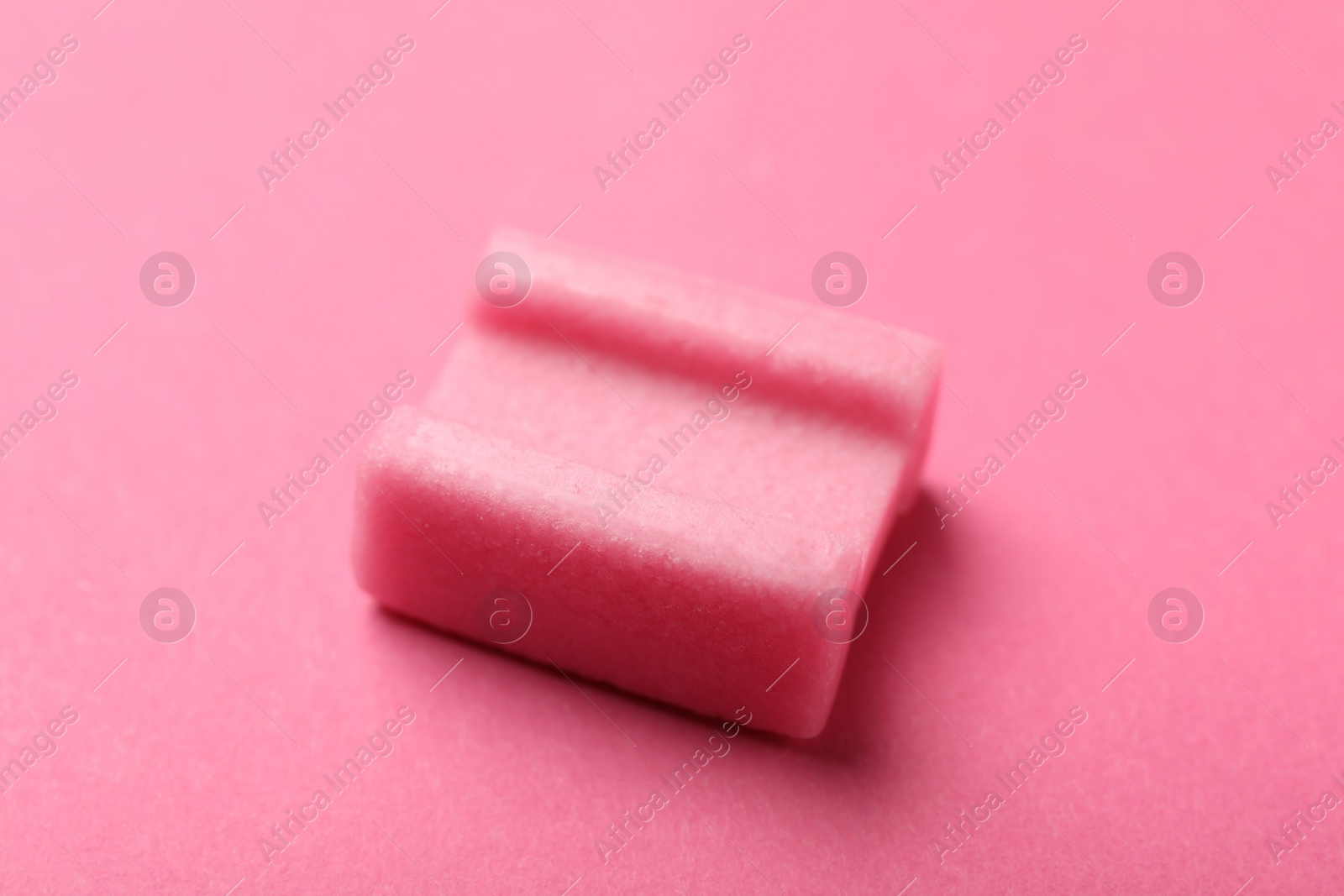 Photo of Tasty chewing gum on pink background, closeup