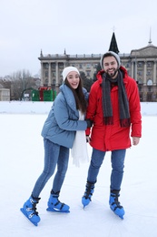 Image of Happy couple skating along ice rink outdoors