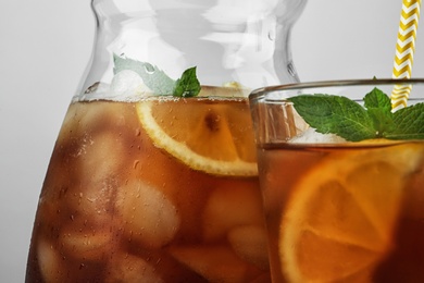 Photo of Jug and glass of delicious iced tea, closeup