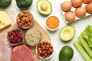 Different fresh products on white wooden table, flat lay. Sources of essential amino acids