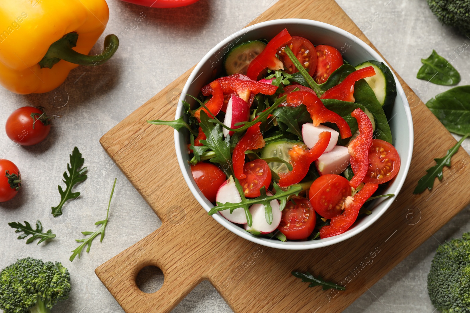 Photo of Tasty fresh vegetarian salad on light grey table, flat lay