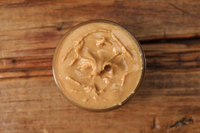 Delicious nut butter in bowl on wooden table, top view