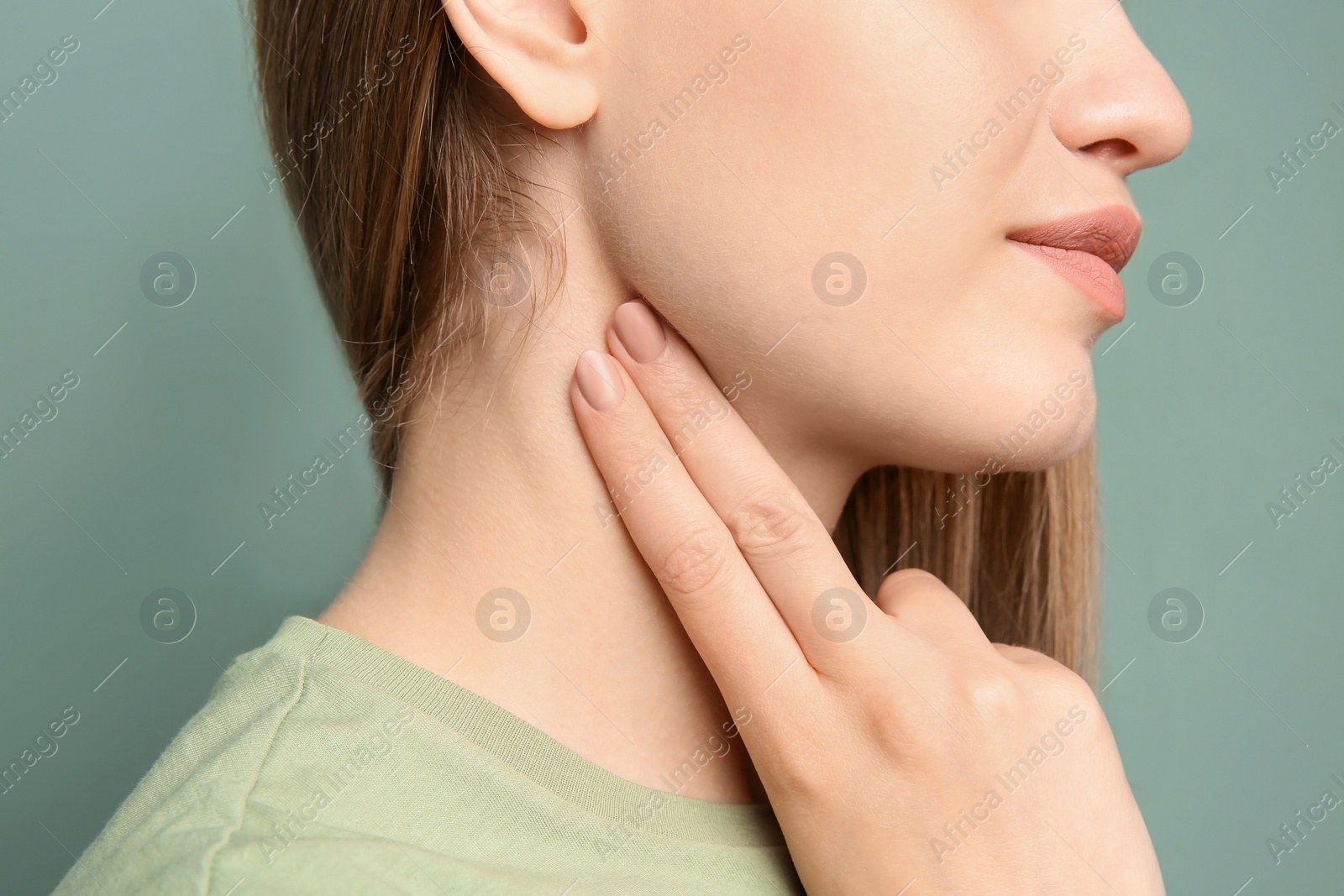Photo of Young woman checking pulse on color background