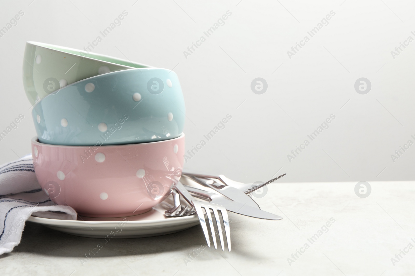 Photo of Beautiful ceramic dishware and cutlery on light grey table, space for text