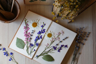Photo of Flat lay composition of beautiful dried flowers and book on wooden table