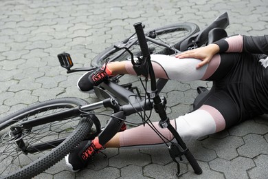 Photo of Woman fallen off her bicycle in park, closeup