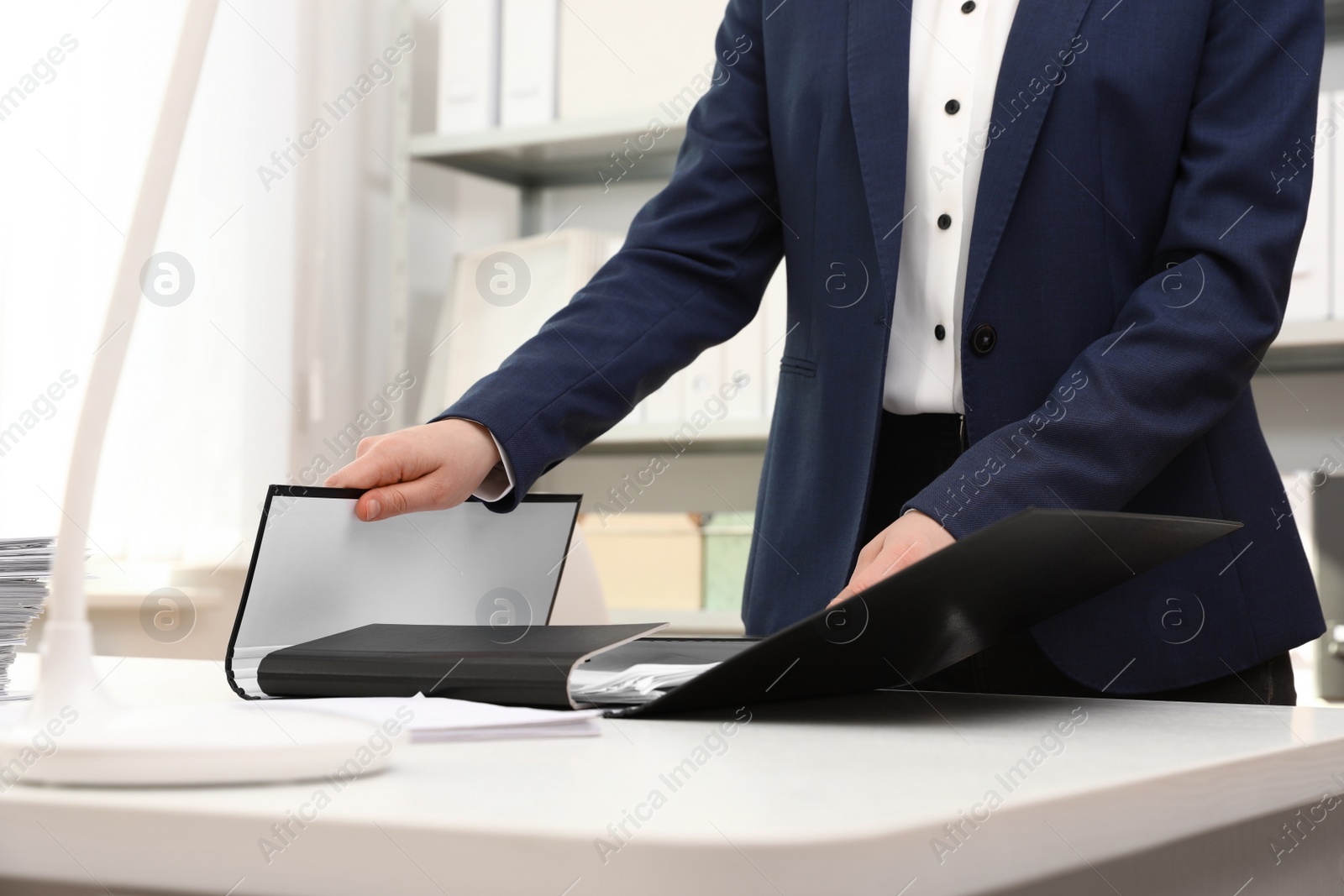 Photo of Woman working with documents at table in office, closeup