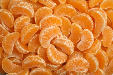 Photo of Delicious tangerine segments as background, top view