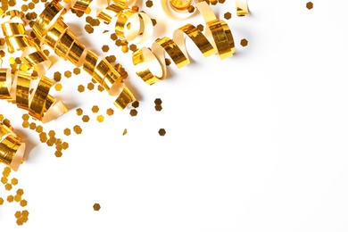 Photo of Shiny golden serpentine streamers and confetti on white background, top view