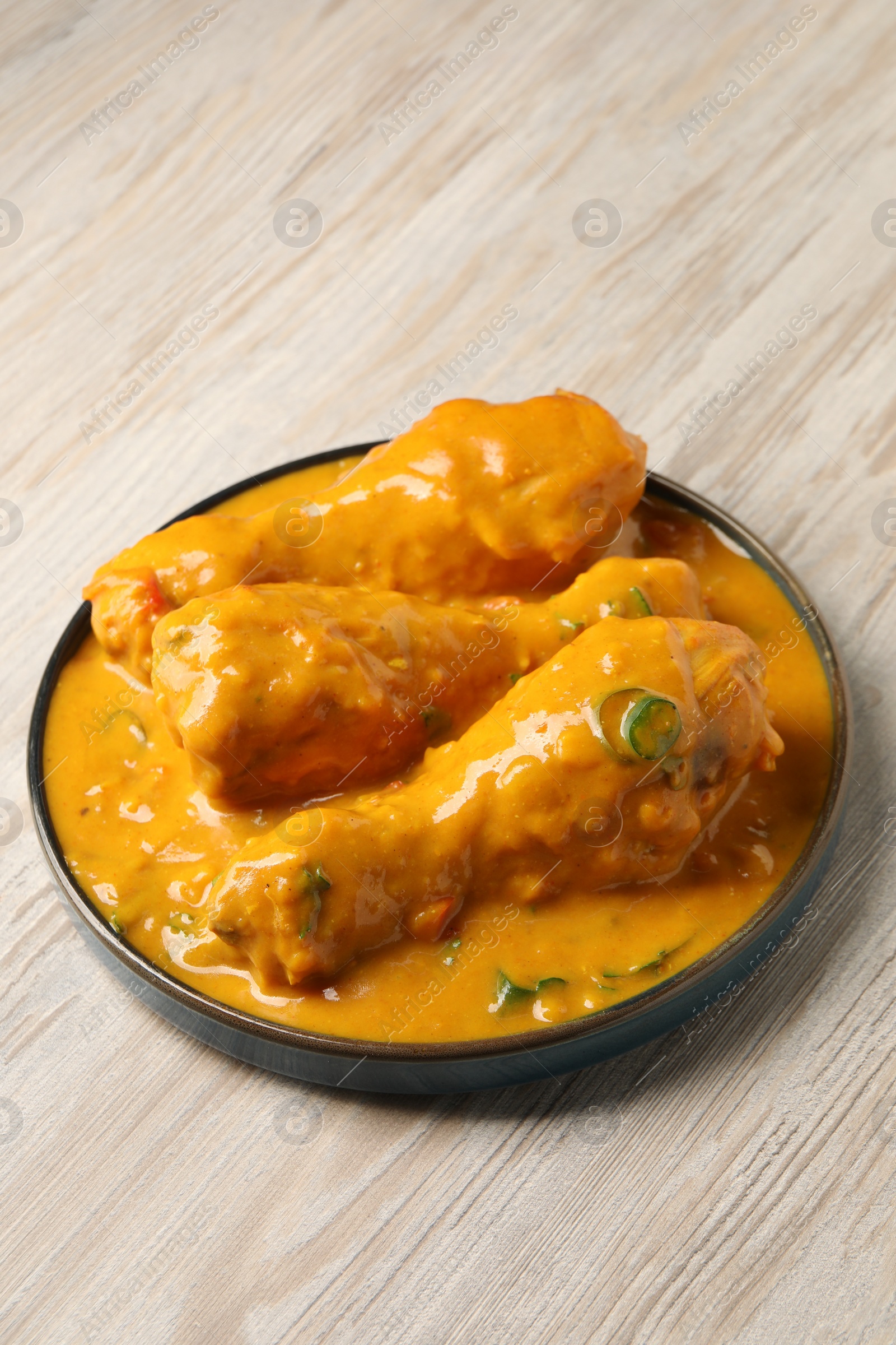 Photo of Tasty fresh chicken curry on wooden table