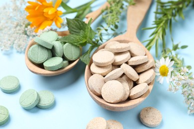 Different pills, herbs and flowers on light blue background, closeup. Dietary supplements