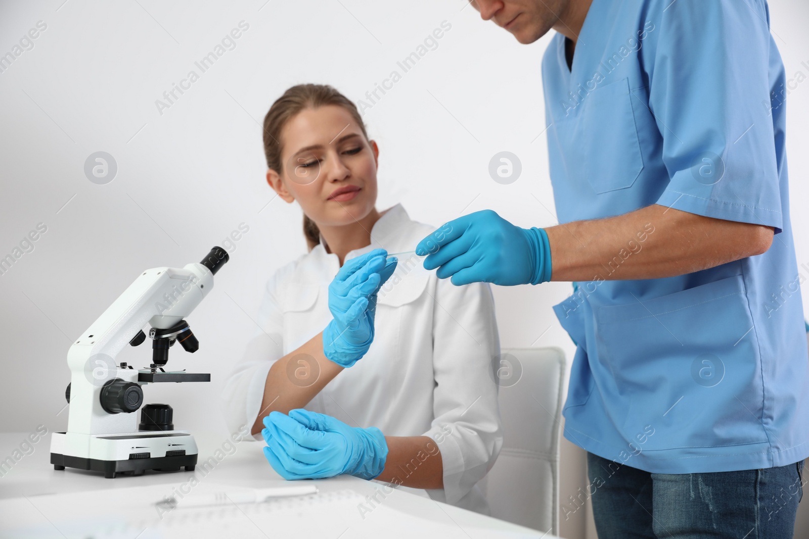 Photo of Medical students with microscope and slide in laboratory