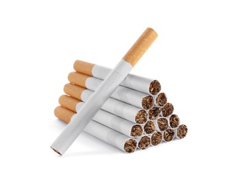 Photo of Pile of cigarettes with orange filters on white background