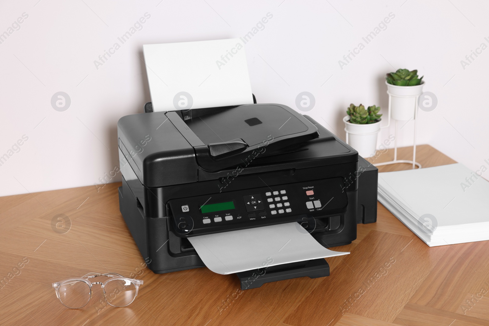 Photo of Modern printer with paper on wooden table indoors