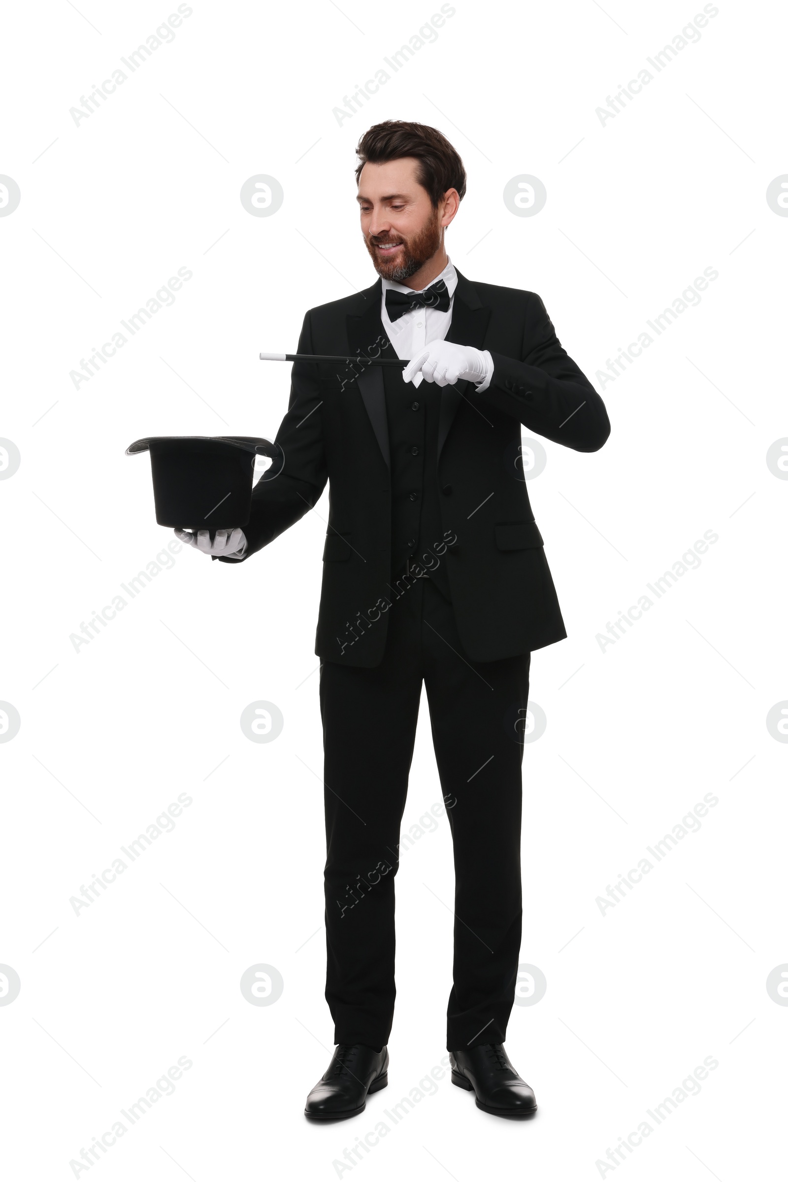 Photo of Happy magician showing magic trick with top hat on white background