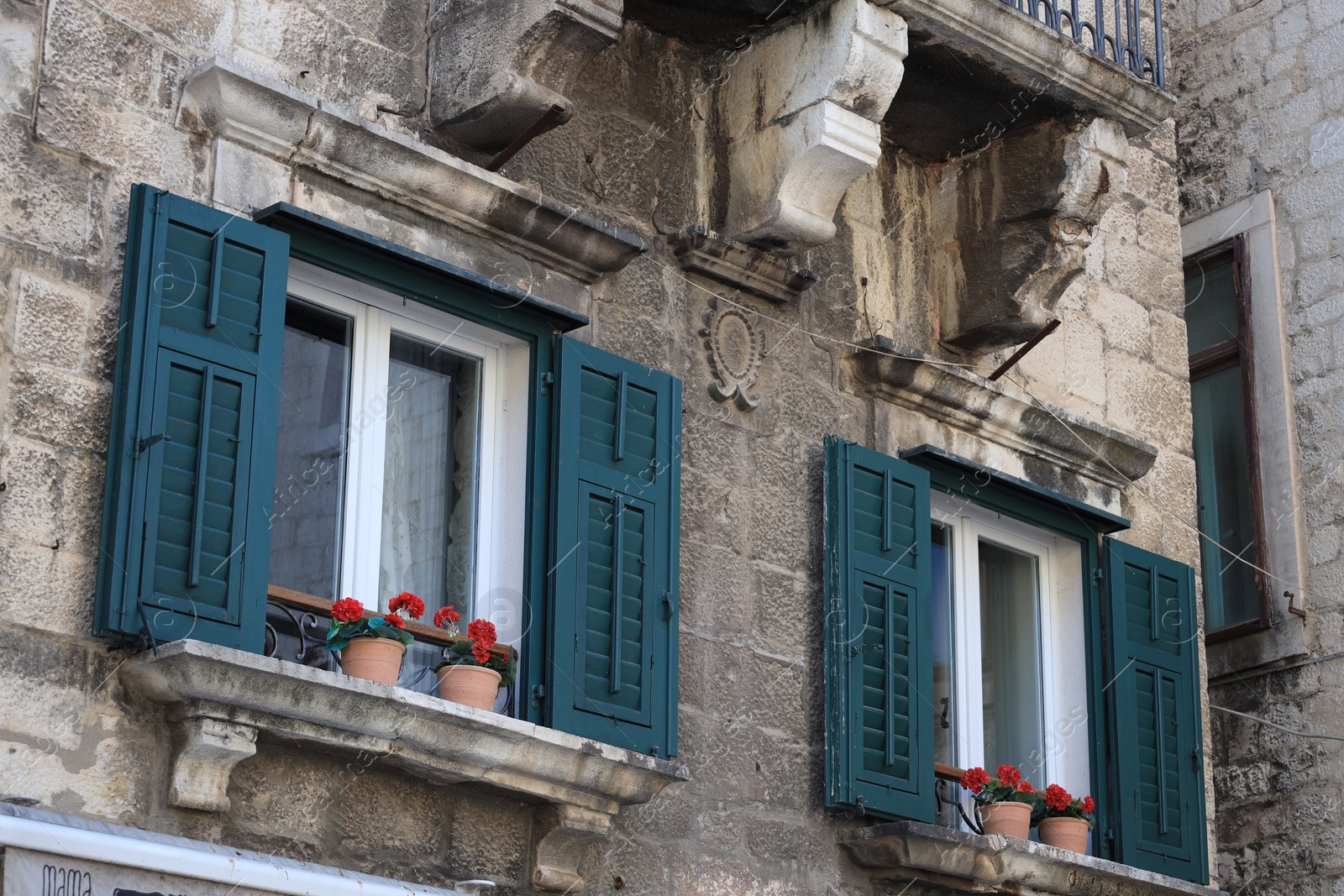 Photo of Old residential building with potted flowers near window