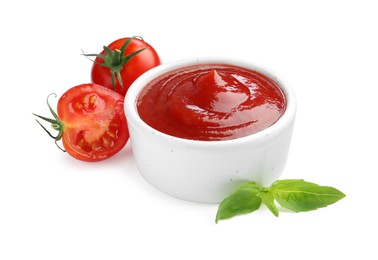 Tasty ketchup in bowl, basil and fresh tomatoes isolated on white