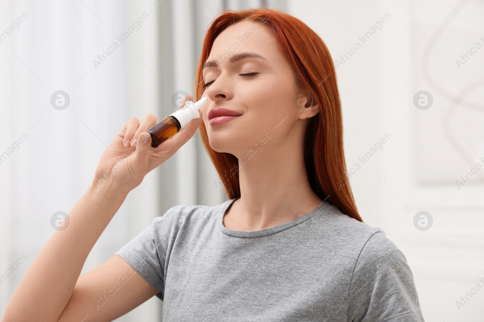 Photo of Medical drops. Woman using nasal spray at home