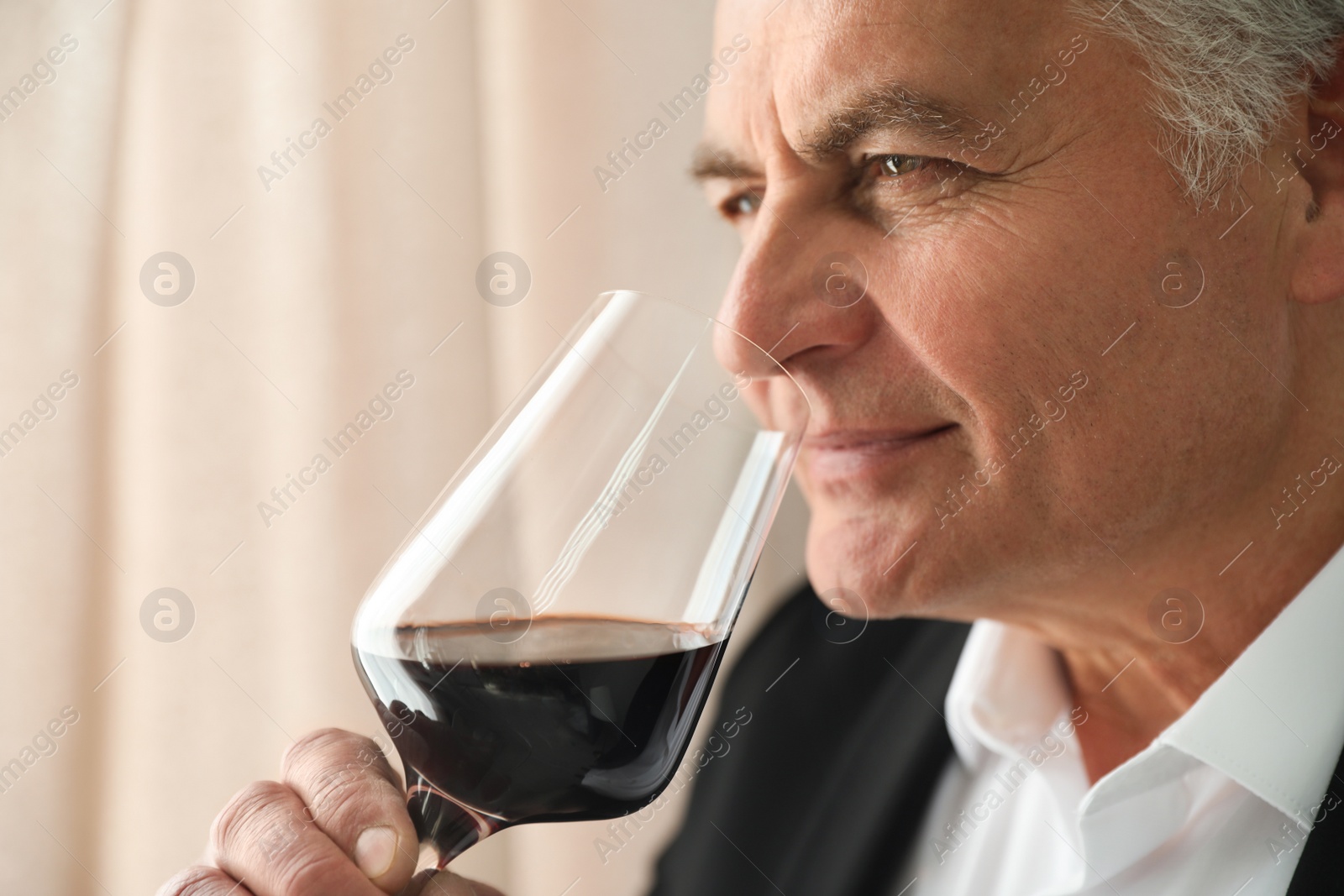 Photo of Senior man with glass of wine indoors