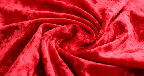 Texture of crumpled red velvet fabric as background, closeup