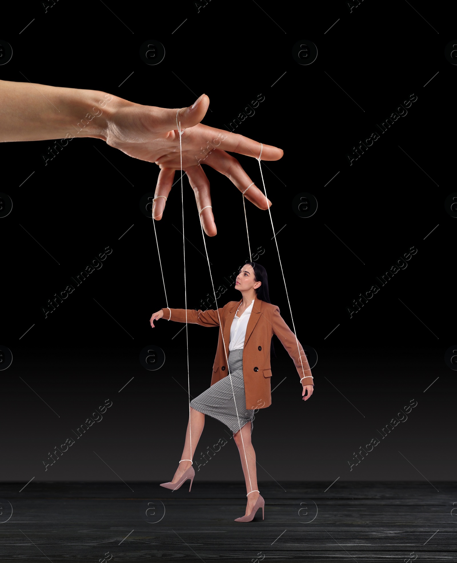 Image of Human relationships demonstrated in puppet show. Worker manipulated by director or manager on black background