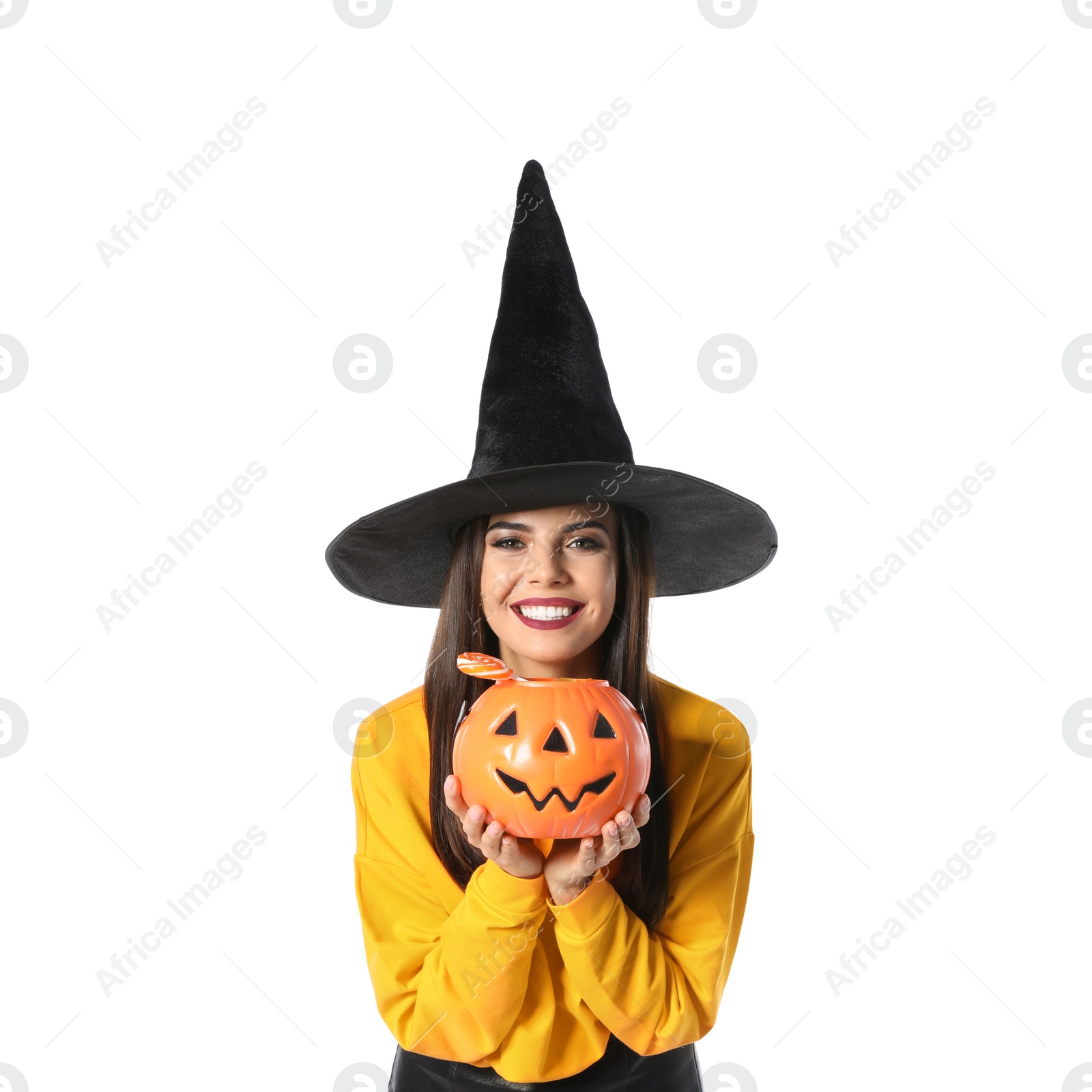 Photo of Beautiful woman wearing witch costume with Jack O'Lantern candy container for Halloween party on white background