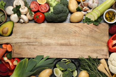 Fresh products and wooden board with space for text, flat lay. Healthy cooking