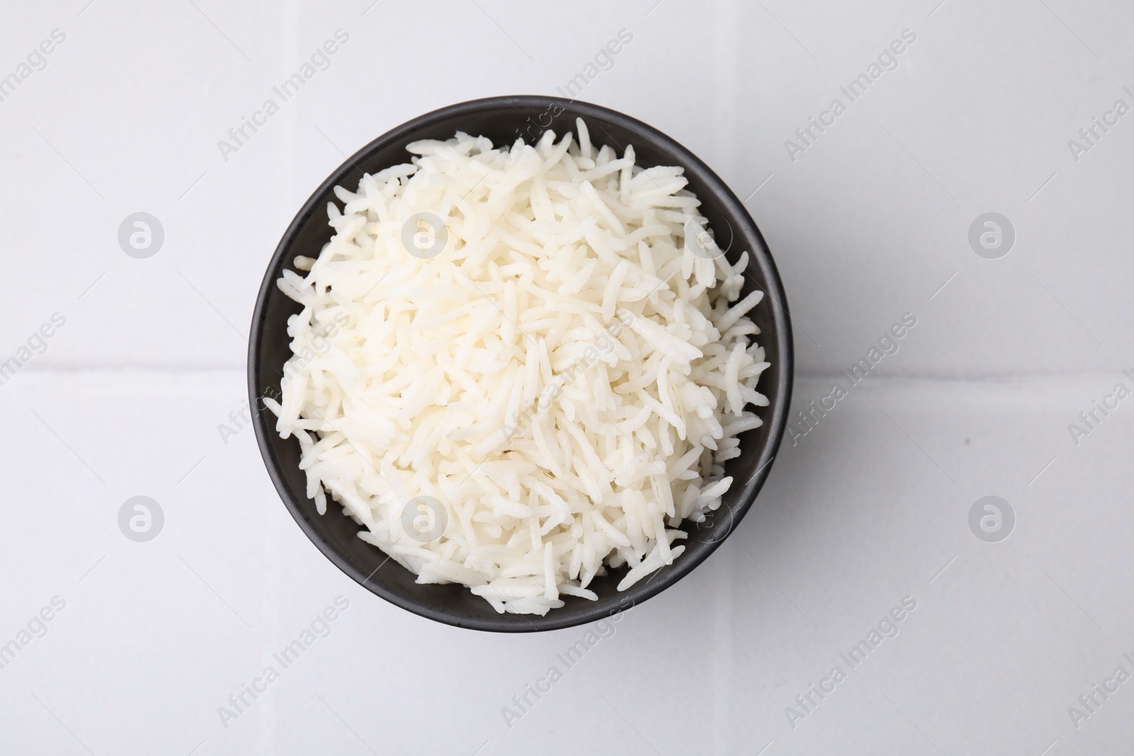 Photo of Bowl of delicious rice on white table, top view