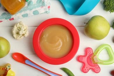 Photo of Flat lay composition with healthy baby food, ingredients and accessories on white wooden table