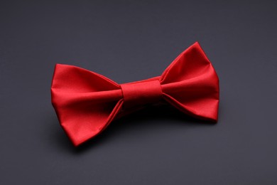 Stylish red bow tie on black background
