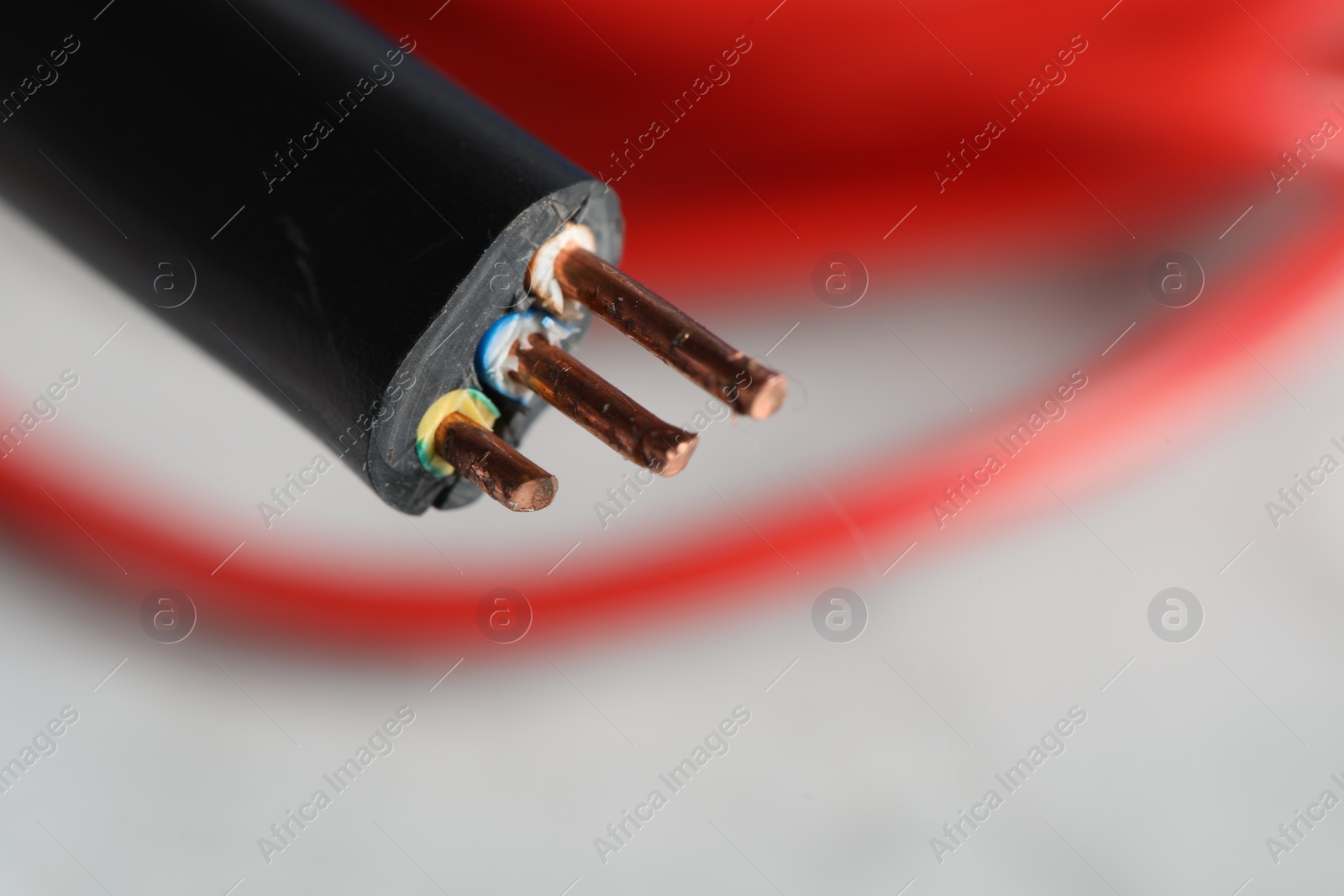 Photo of Black electrical wire on blurred background, closeup. Space for text