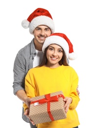 Young couple with Christmas gift on white background