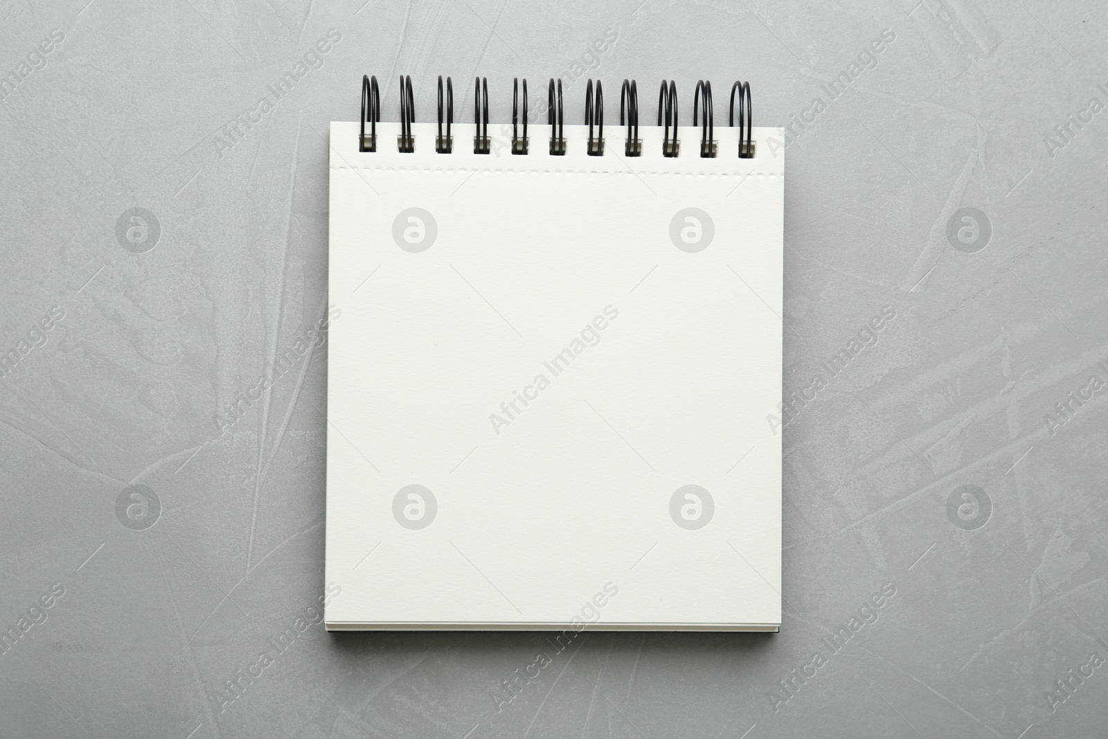 Photo of Notebook on light textured table, top view. Space for text